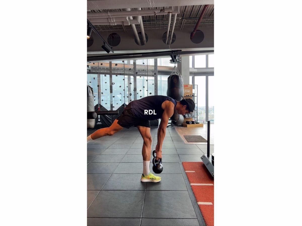 Man performing a Romanian Deadlift (RDL) with a kettlebell in a gym, demonstrating How to Add Text to Instagram Reels for fitness tutorials.